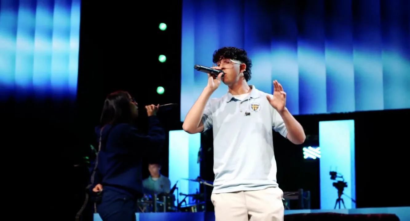 An FCC School student leading worship at chapel